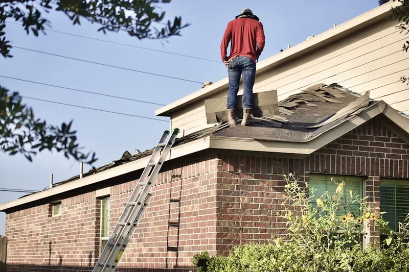Professional roofer working on a residential roof in Eileen Gardens
